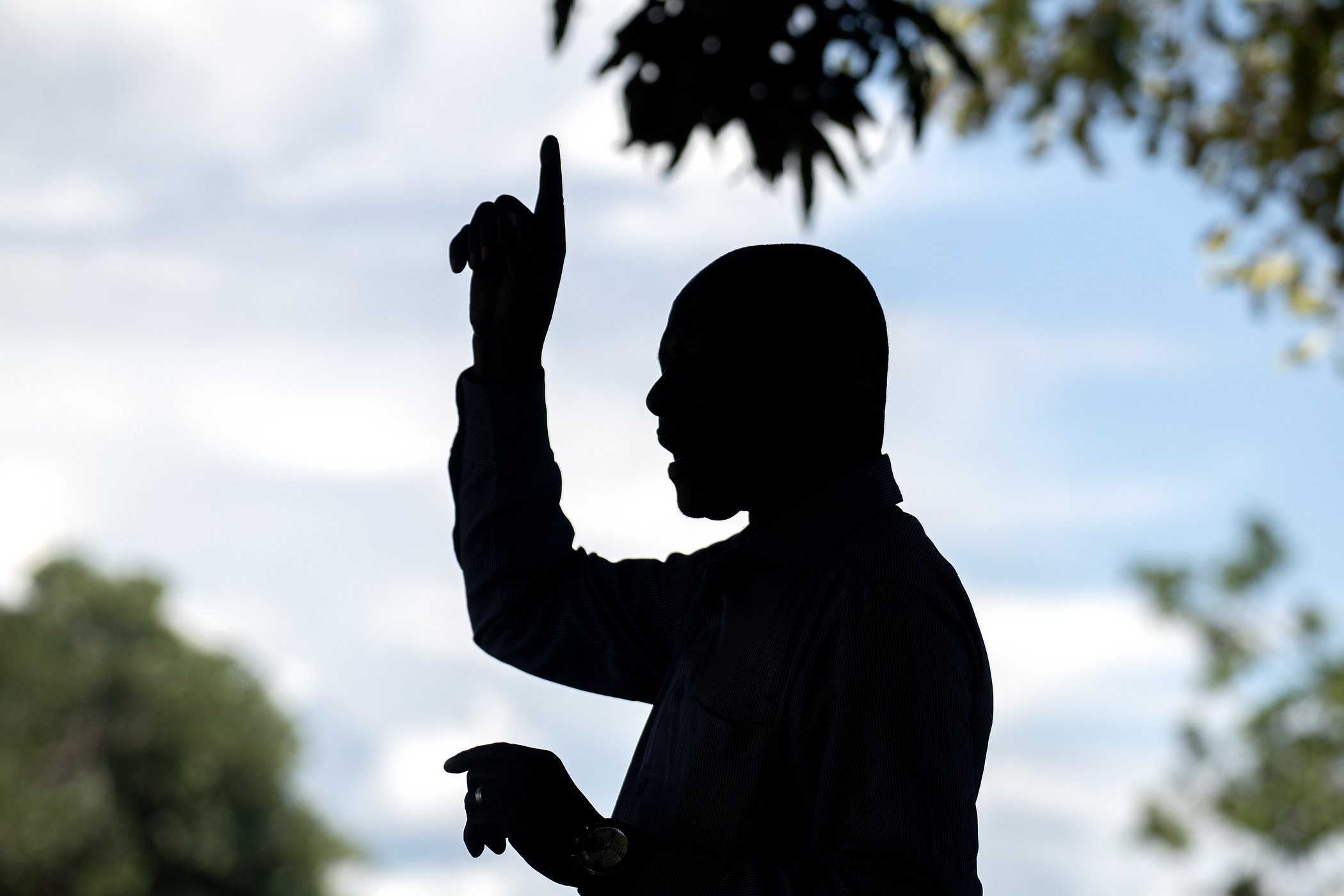 Silhouette of an African preacher pointing to the sky as he teaches