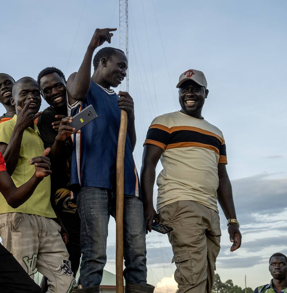 Young men and leaders smiling together in Kajo Keji, South Sudan