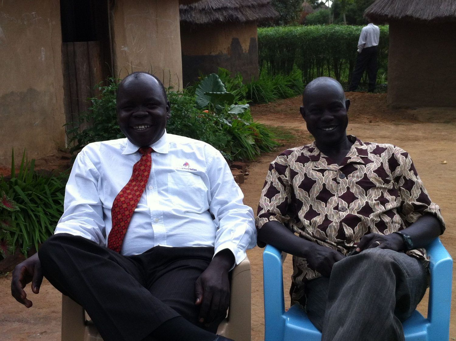 Two South Sudanese church leaders laughing together outside a tukel, early years